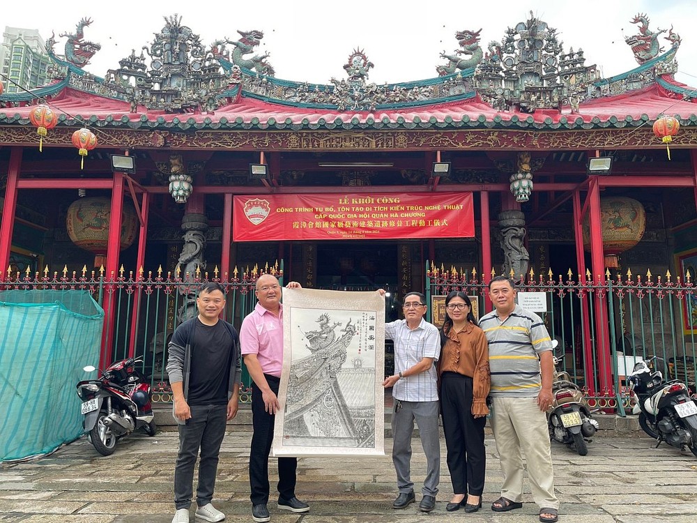 赵骞先生（左二）接下《海国安澜》画作。左四、五为郑钊城与姚金鸾画家夫妇。