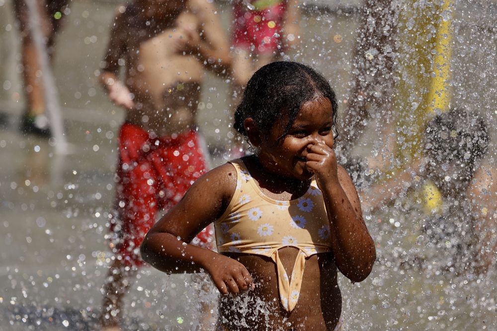 2024年6月22日，一名儿童在美国加利福尼亚州奥兰治县的一处喷泉戏水降温。（图：新华社）