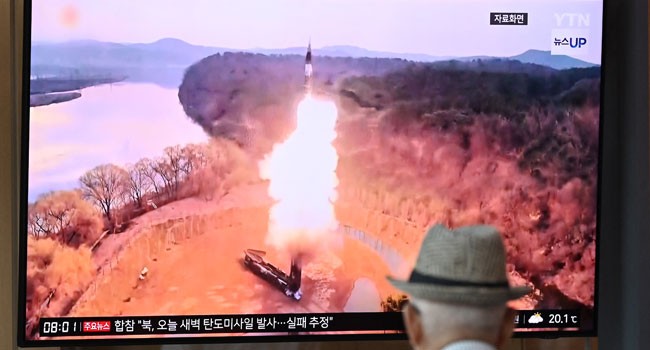 2024年6月26日，首尔火车站，一名男子观看电视屏幕上播放的新闻广播，其中播放了朝鲜导弹试验的镜头。（图：AFP）
