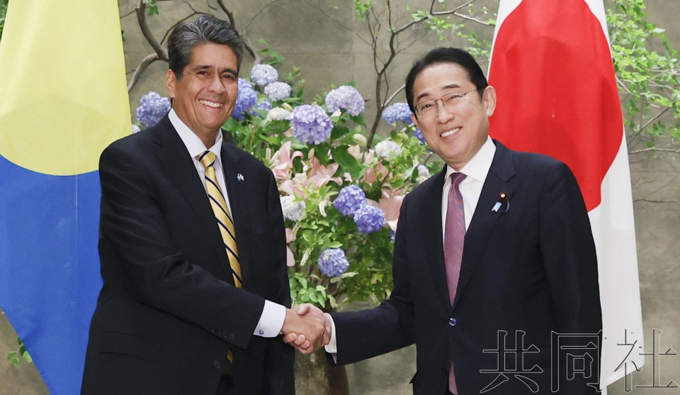 6月4日，日本首相岸田文雄（右）与帕劳总统惠普斯握手。（图：共同社）