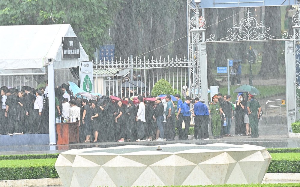 人群冒着大雨排队登记进入统一会场吊唁阮富仲总书记。