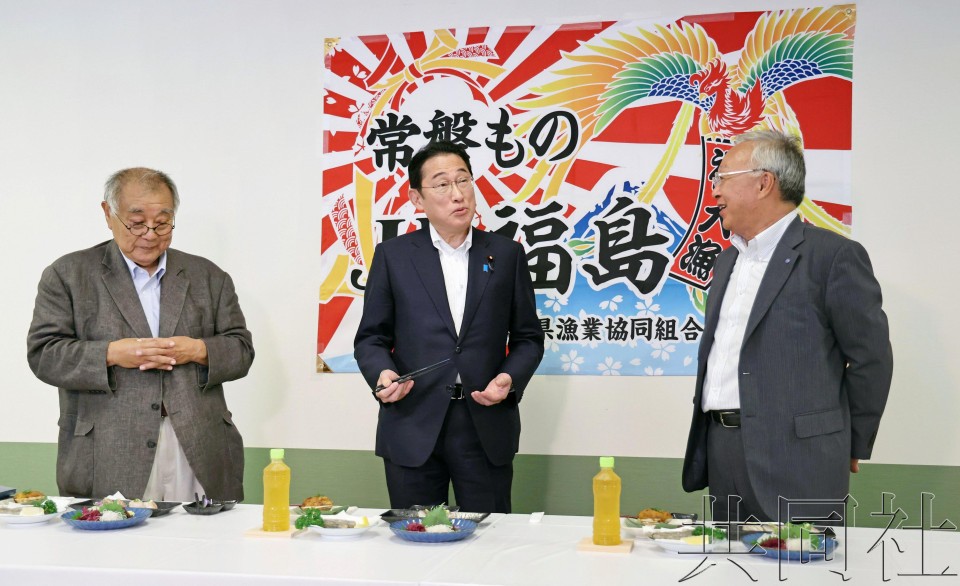 日本首相岸田文雄赴当地鱼市场试食。（图：共同社）