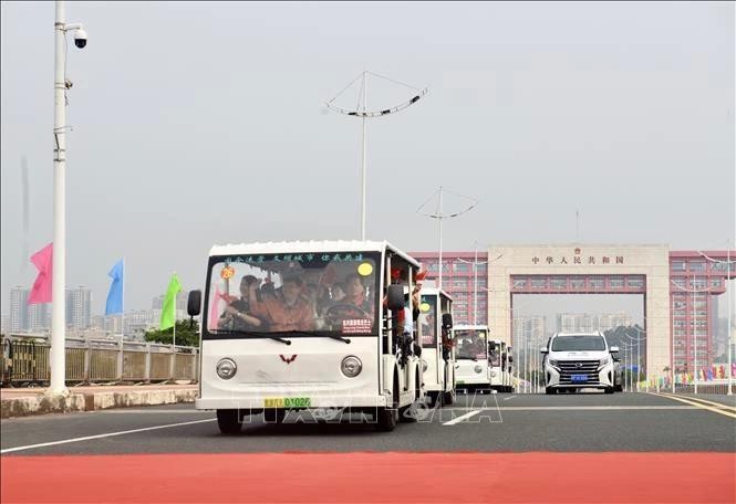 一团旅游车队从中方边境口岸开往我国广宁省芒街国际口岸。（图：越通社）