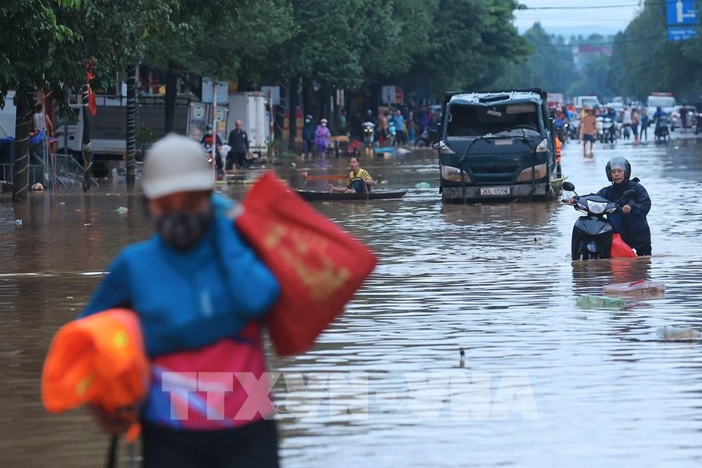 9月11日上午，太原市多条街道仍被洪水淹没，人们在街道上涉水而行。（图：越通社）