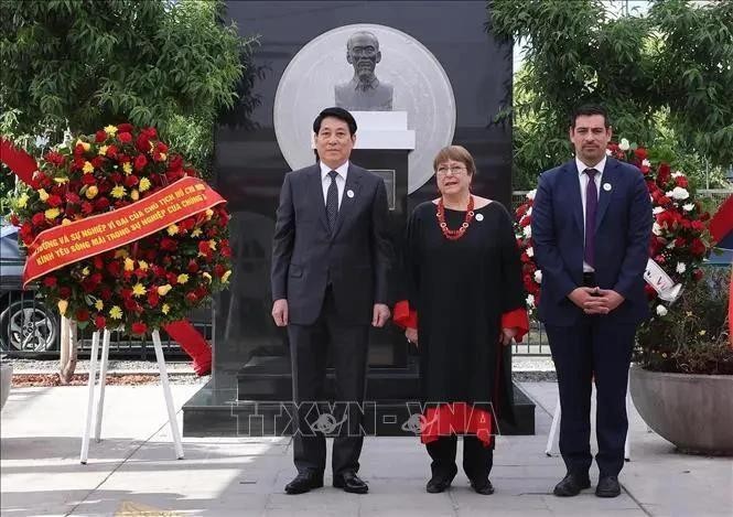 向胡志明主席塑像敬献花圈仪式上的国家主席梁强（左一）与智利前总统米歇尔·巴切莱特·赫里亚和Cerro Navia 区区长塔马约。（图：越通社）