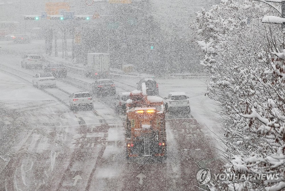 除雪车展开除雪工作。（图：韩联社）