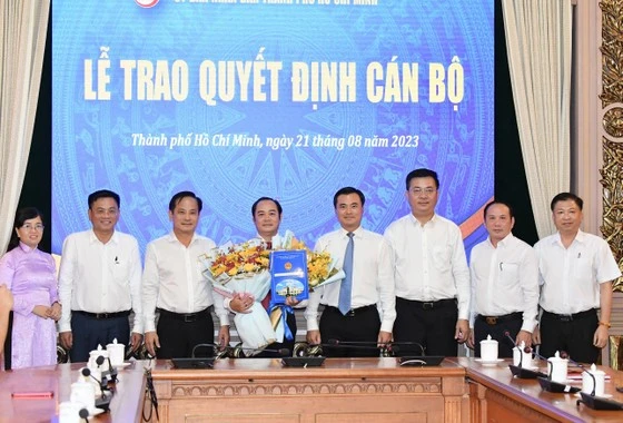 PCT UBND TPHCM Bùi Xuân Cường (thứ 4 từ trái qua) chúc mừng tân PCT huyện Bình Chánh Huỳnh Cao Cường