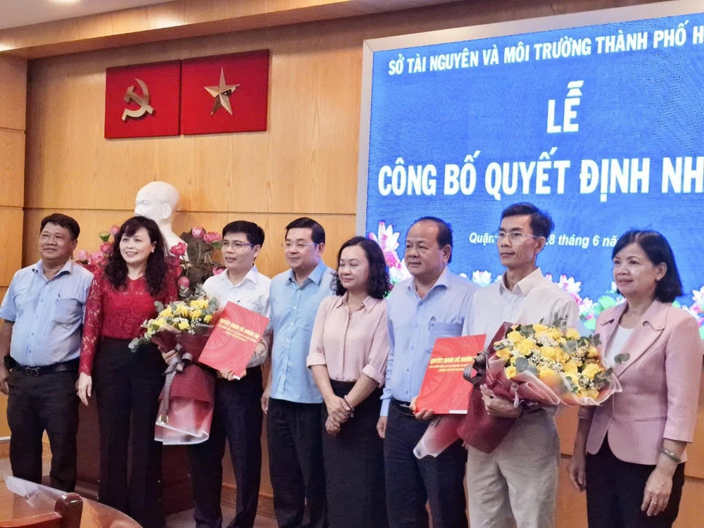 Ông Phạm Văn Tùng (thứ 3 từ trái) và ông Nguyễn Minh Hiếu (thứ 2 từ phải) nhận hoa chúc mừng của Giám đốc Sở TNMT và Phó chủ tịch UBND quận 12 