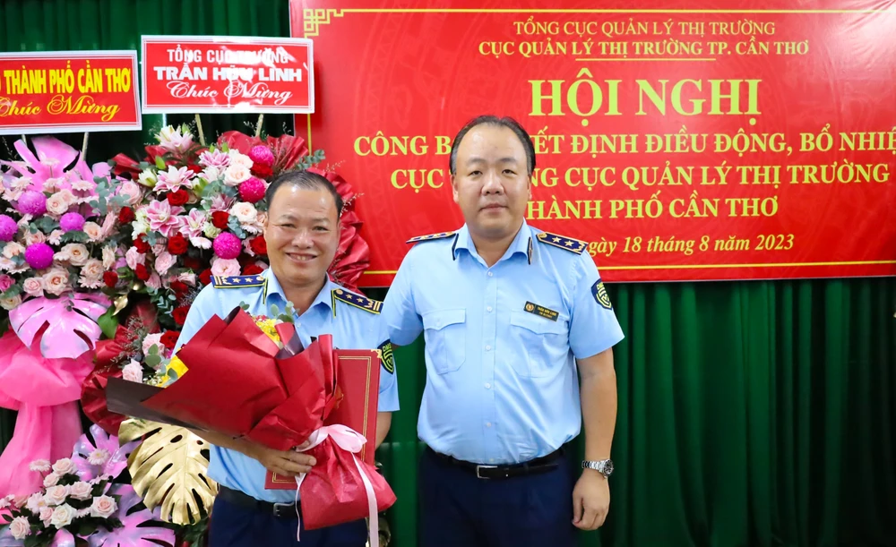 Ông Trần Hữu Linh (phải), Tổng Cục trưởng Cục QLTT, trao quyết định điều động, bổ nhiệm cho ông Nguyễn Hùng Em