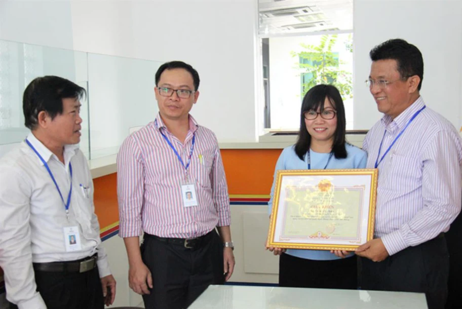 Ông Ngô Tấn Cư, Giám đốc Điện lực Đà Nẵng tặng giấy khen cho chị Trần Thị Anh 