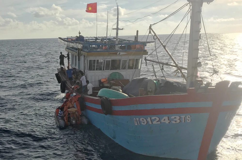 Các nhân viên tàu SAR 412 đưa xuồng cao su tiếp cận tàu cá và chuyển ngư dân Lê Thanh Hải sang tàu SAR 412 đưa về đất liền cấp cứu