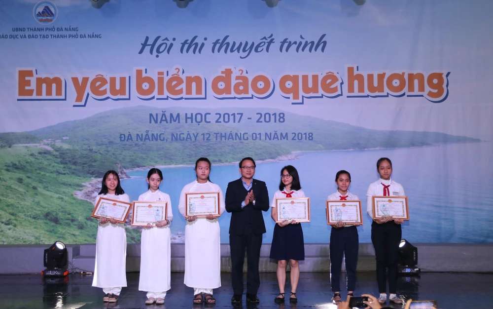 Ông Nguyễn Đình Vĩnh, Giám đốc Sở GD-ĐT TP Đà Nẵng trao Giấy khen cho các học sinh đoạt giải nhất cuộc thi “Em viết về Đà Nẵng – Thành phố môi trường”