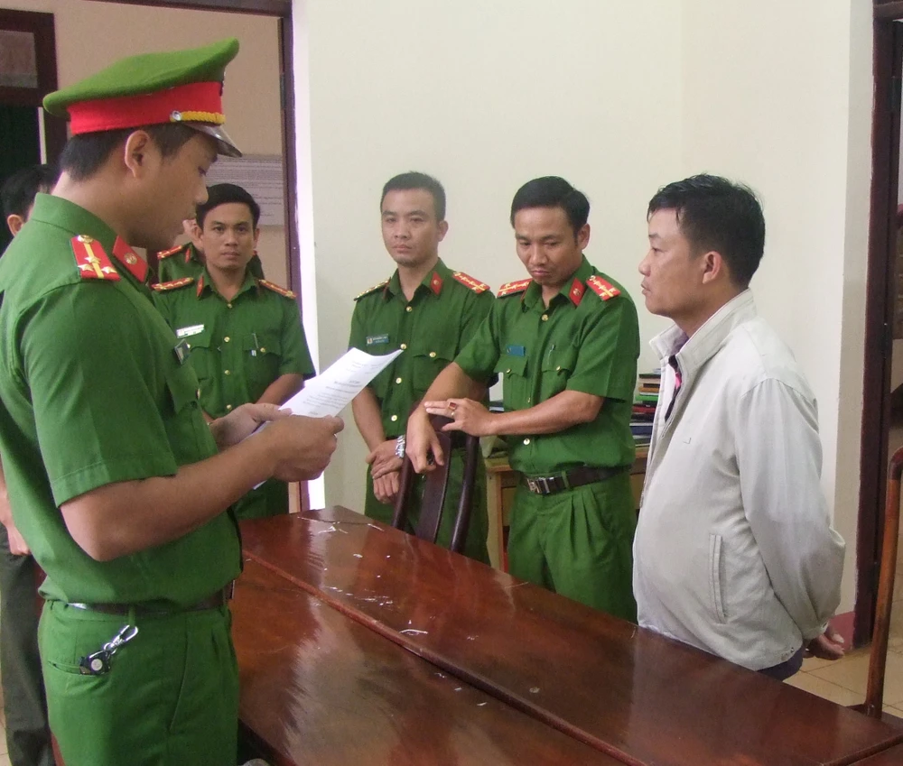 Cơ quan công an đọc lệnh bắt ông Trần Đức Tính (áo trắng, bên phải ảnh). Ảnh CÔNG HOAN