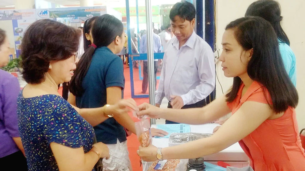 Người tiêu dùng Hà Nội tham khảo các mẫu thuỷ sản chế biến được doanh nghiệp giới thiệu tại hội chợ sáng nay