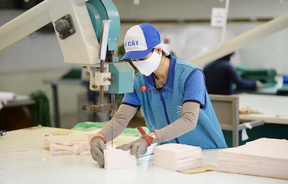 Công nhân tại Công ty Dệt kim Đông Xuân tăng công suất cắt may khẩu trang để đáp ứng nhu cầu mua khẩu trang giá bình ổn của người dân cả nước. Ảnh: Vinatex