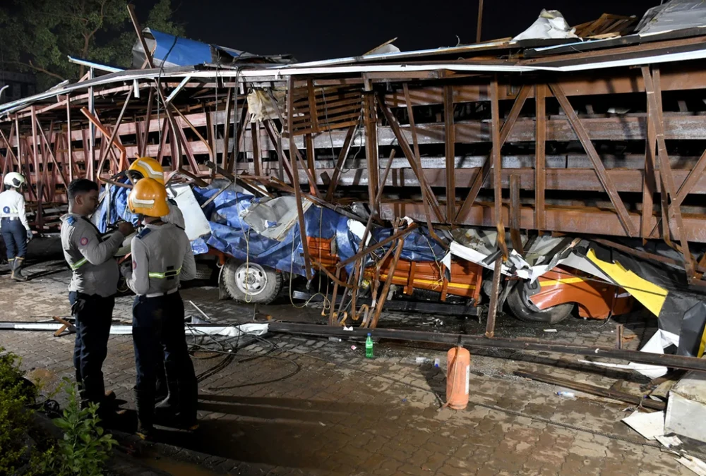  Những chiếc xe bị biển quảng cáo đè bẹp trong trận mưa bão ở Mumbai, Ấn Độ. Ảnh REUTERS