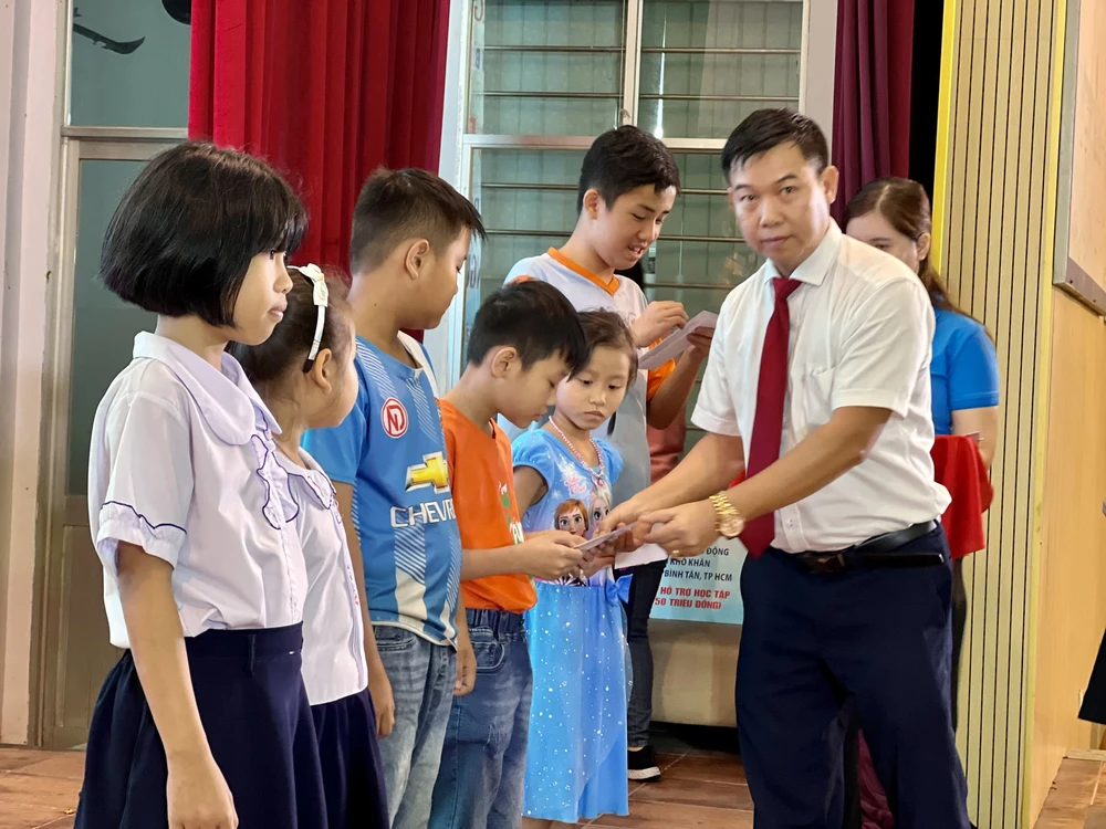 Ông Nguyễn Văn Nhì, Phó Giám đốc Ngân hàng Agribank, chi nhánh KCN Tân Tạo trao học bổng cho các em học sinh. Ảnh: CTV
