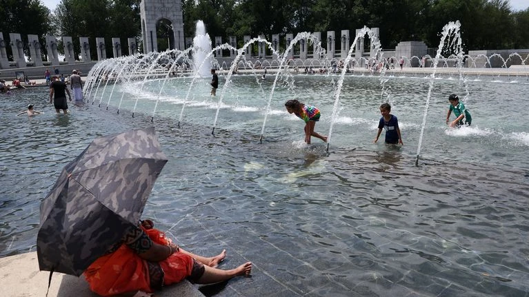 Khách du lịch đến đài phun nước ở Washington D.C tránh nắng. Nguồn: Getty Images