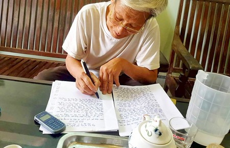 The old man, on behalf of people from Dong Tam commune, writing an open letter to the chairman of the Hanoi People’s Committee on April 21 (Photo: SGGP)
