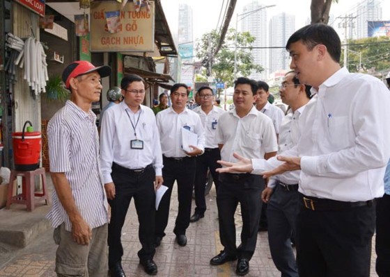 Chairman of District 7 People’s Committee Le Hoa Binh (R) mobilizes residents not to encroach roads and pavements to do business in March (Photo: SGGP)