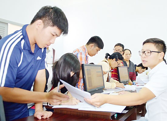 Students complete aperwork to applyfor the exam (Photo: SGGP)