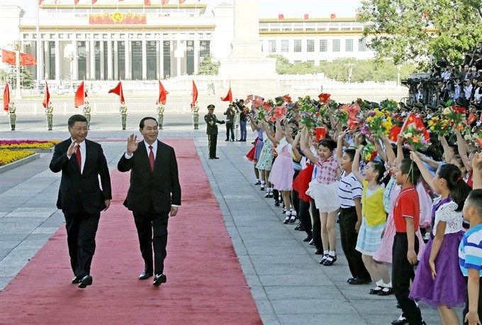 President Tran Dai Quang (right) and Party General Secretary and President of China Xi Jinping attend a welcoming ceremony outside the Great Hall of the People in Beijing, China on Thursday. (Photo: VNA/VNS)