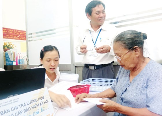 The old woman receives social insurance premium at an agency in HCMC (Photo: SGGP)