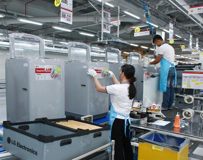  Employees of LG Electronics Vietnam, a Korean-invested firm, operate a production line at the firm's factory in Hanoi. (Photo: VNA/VNS)