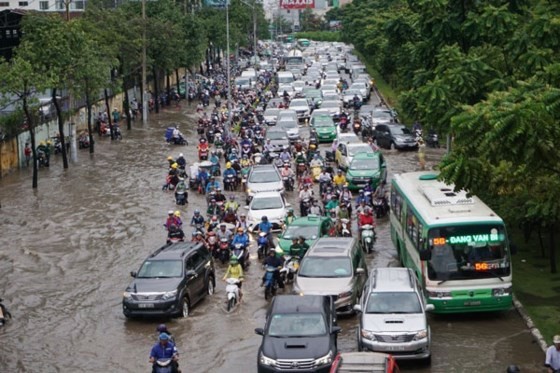 Nguyen Huu Canh street is badly flooded after a heavy rain on June 21 (Photo: SGGP)