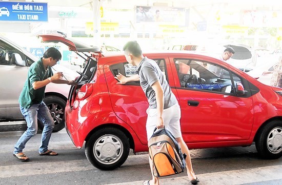 An Uber taxi cab picks up passengers in HCMC (Photo: SGGP)