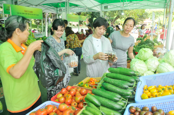 Residents buy safe farm produce at the safe farm produce fair at Le Thi Rieng park on September 24 (Photo: SGGP)