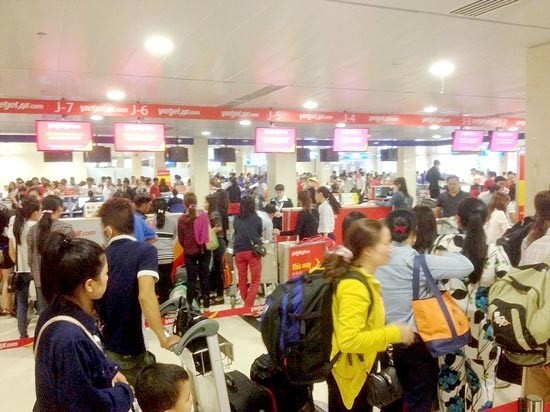 Passengers wait for their turns at airport check-in counters (Photo: SGGP)