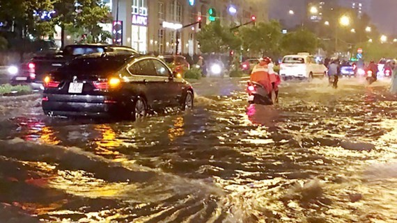 Nguyen Huu Canh street is inundated after a heavy rain (Photo: SGGP)