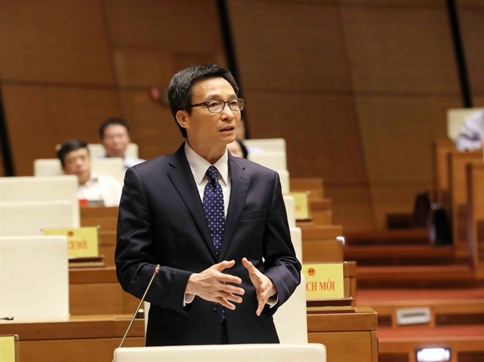 Deputy Prime Minister Vu Duc Dam responds to queries from National Assembly deputies yesterday afternoon. (Photo: VNA/VNS)