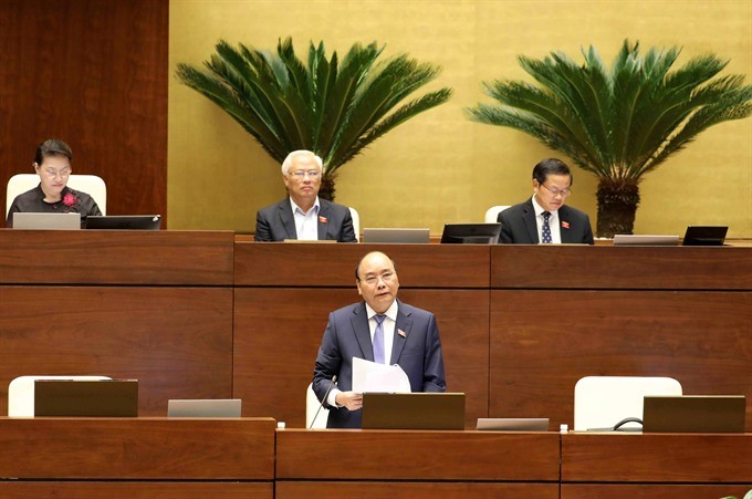 Prime Minister Nguyen Xuan Phuc (standing) responds to questions from National Assembly deputies on Saturday, November 18, the last day of a three-day hearing of cabinet members. (Photo: VNA/VNS)