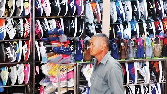 Shoes faking famous brand names are sold rampantly in the market (Photo: SGGP)
