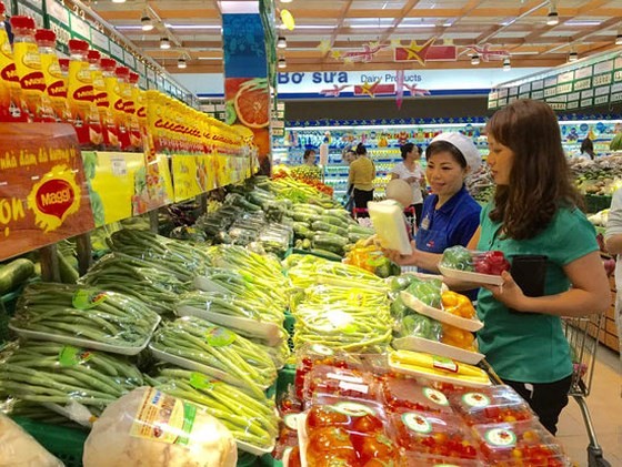 A customer buying vegetables at a supermarket in HCMC (Photo: SGGP)