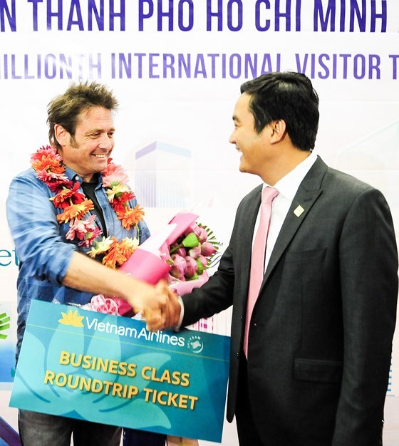 Mr. Bui Ta Hoang Vu, director of the Department of Tourism, congratulates the six millionth visitor to HCMC this year on December 15 (Photo: SGGP)