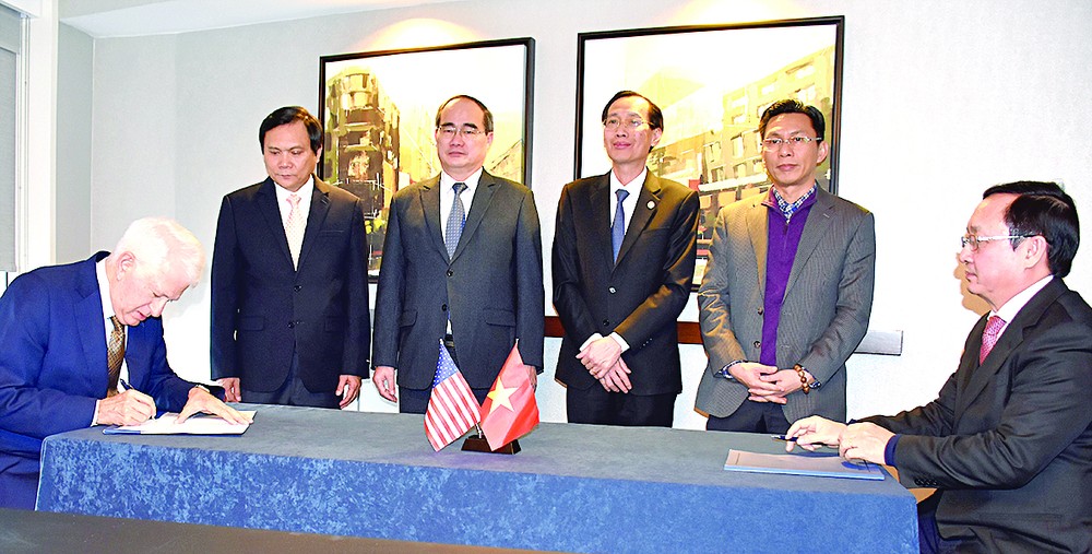 Director of HCMC National University Huynh Thanh Dat (R) and Principle of UCLA Gene D.Block sign a cooperation agreement in Washington D.C. on December 17 (Photo: SGGP)