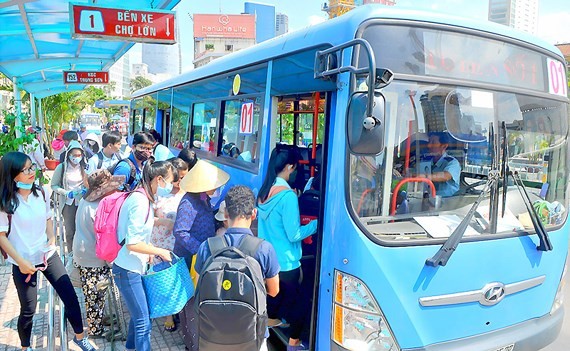 Passengers get on a bus in HCMC (Photo: SGGP)