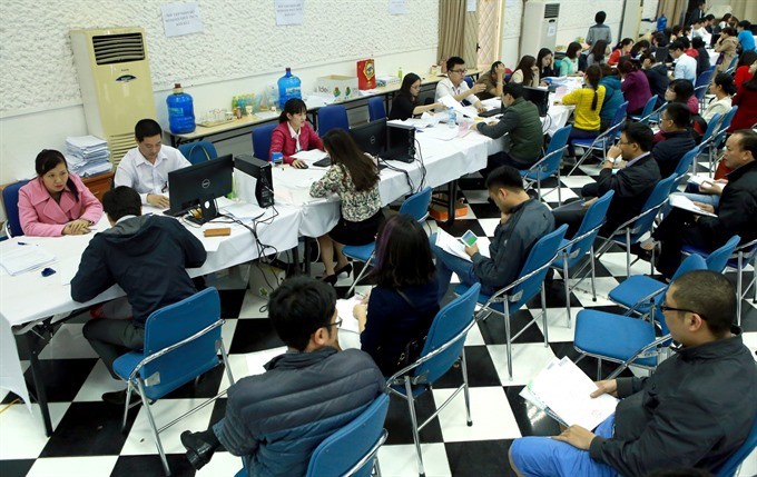 People wait for their turn to complete tax procedures at the Hanoi Tax Department.(Photo: VNA/VNS)