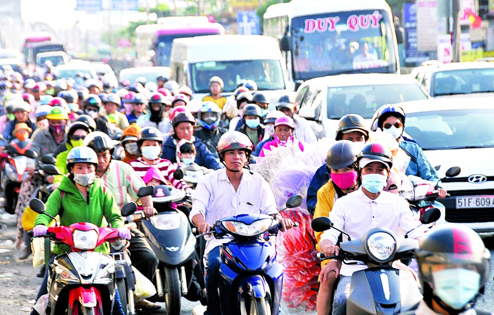 People from the Mekong Delta streaming back to HCMC in National Highway 1A, Binh Chanh district on February 20 (Photo: SGGP)