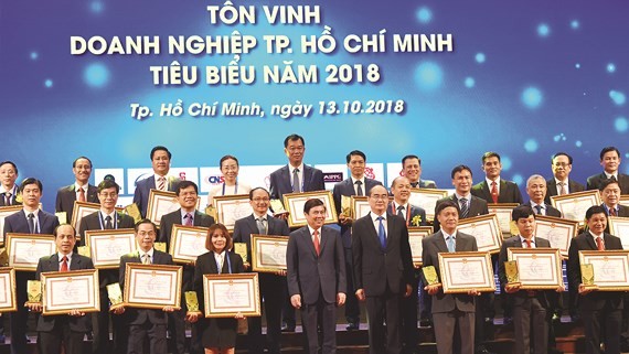 HCMC Party leader Nguyen Thien Nhan and chairman of HCMC People’s Committee Nguyen Thanh Phong congratulates oustanding businesses 2018 in HCMC on October 13 (Photo: SGGP)