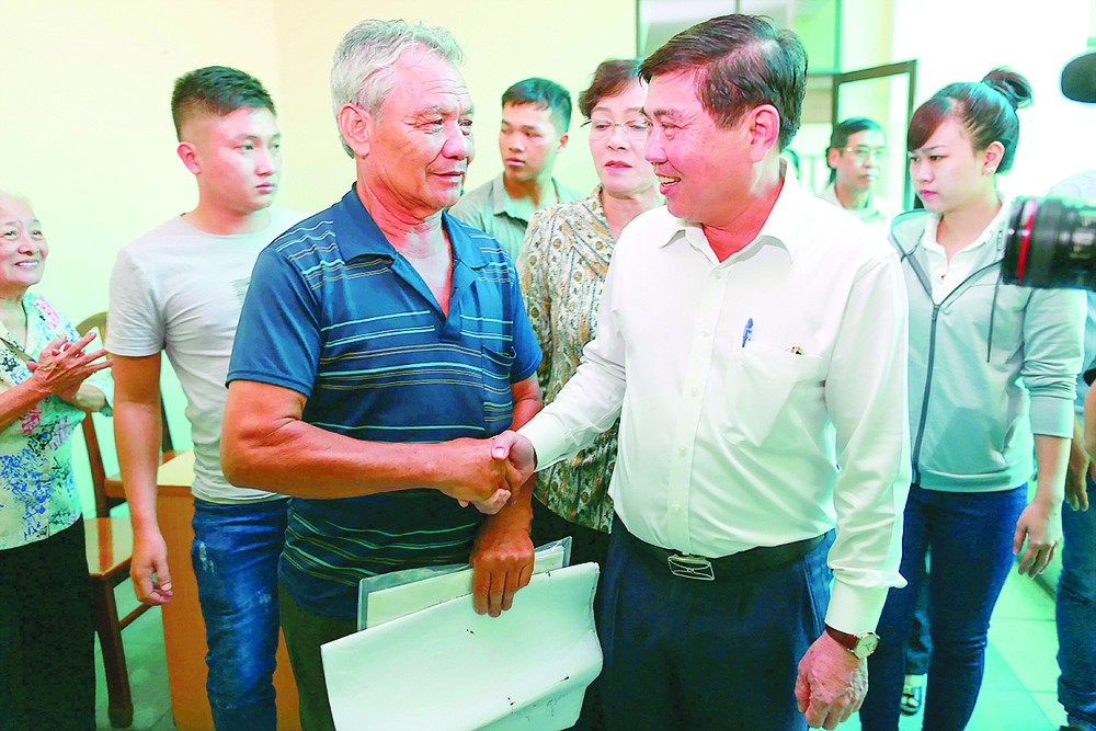 Chairman Nguyen Thanh Phong shakes hands with a residents at a meeting with people relating to Thu Thiem new urban area on October 18 (Photo: SGGP)