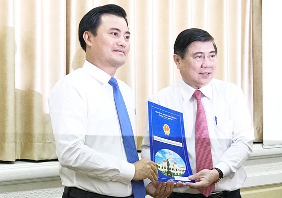 Chairman Nguyen Thanh Phong gives Mr. Bui Xuan Cuong (L) the decision to appoint him to head of Urban Railway Management Board (Photo: SGGP)