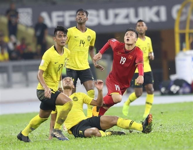 Nguyen Quang Hai (shirt no.19) is surrounded by Malaysian players (Source: VNA)
