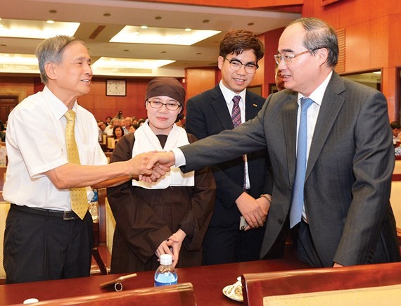 HCMC Party Chief Nguyen Thien Nhan shakes hands with an overseas Vietnamese at the meeting on January 24 (Photo: SGGP)