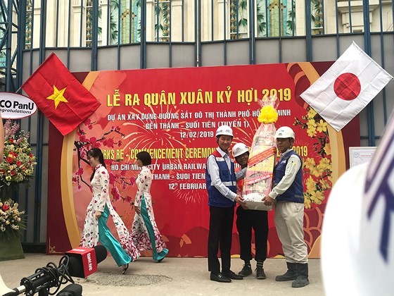 Deputy chairman  of HCMC People's Committee Tran Vinh Tuyen (L) gives workers of Ben Thanh-Suoi Tien metro project New Year presents (Photo: SGGP)