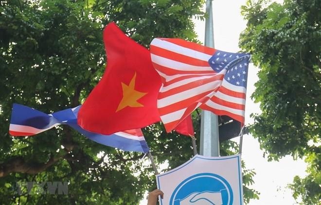 National flags of the DPRK, the US and Vietnam attached to a plaque with a friendship symbol of handshake are decorating many streets downtown Hanoi. (Photo: VNA)