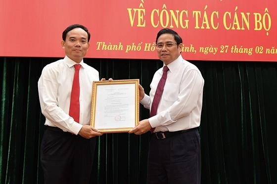 Head of the Commission for Organizing and Personnel of the Communist Party of Vietnam Pham Minh Chinh (R) gives the Politburo’s decision to appoint Mr. Tran Luu Quang to the standing deputy secretary of HCMC Party Committee on February 27 (Photo: SGGP)